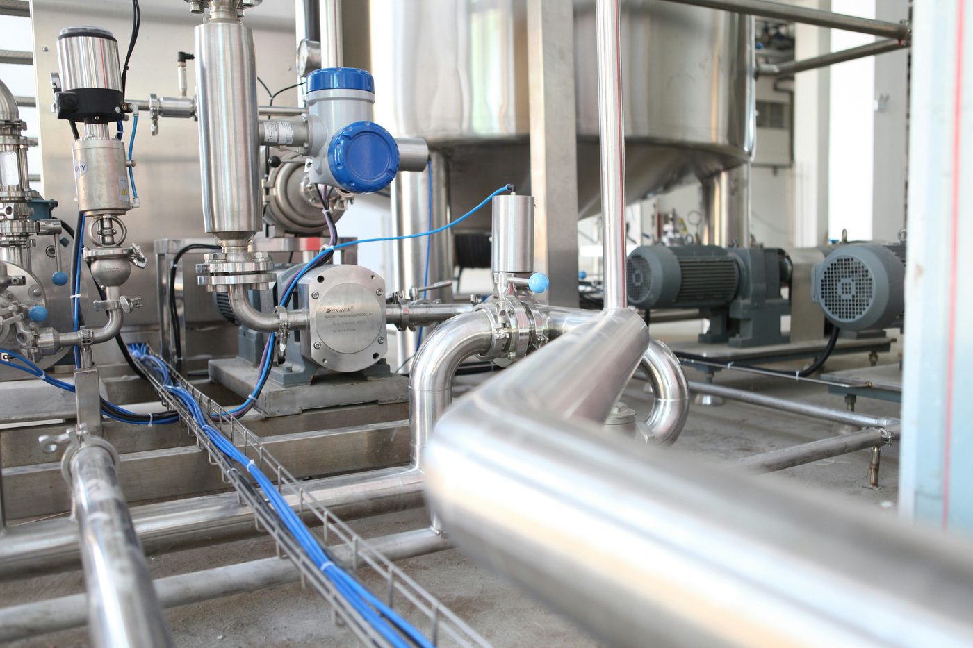 Bombas, motores y tuberías de acero inoxidable en planta de proceso