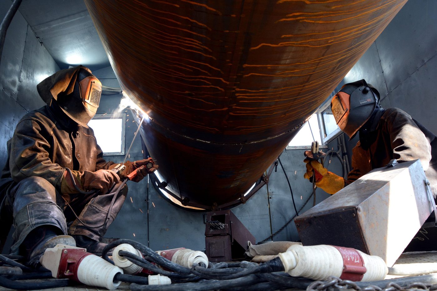 Técnicos de pailería dando mantenimiento a un tanque industrial